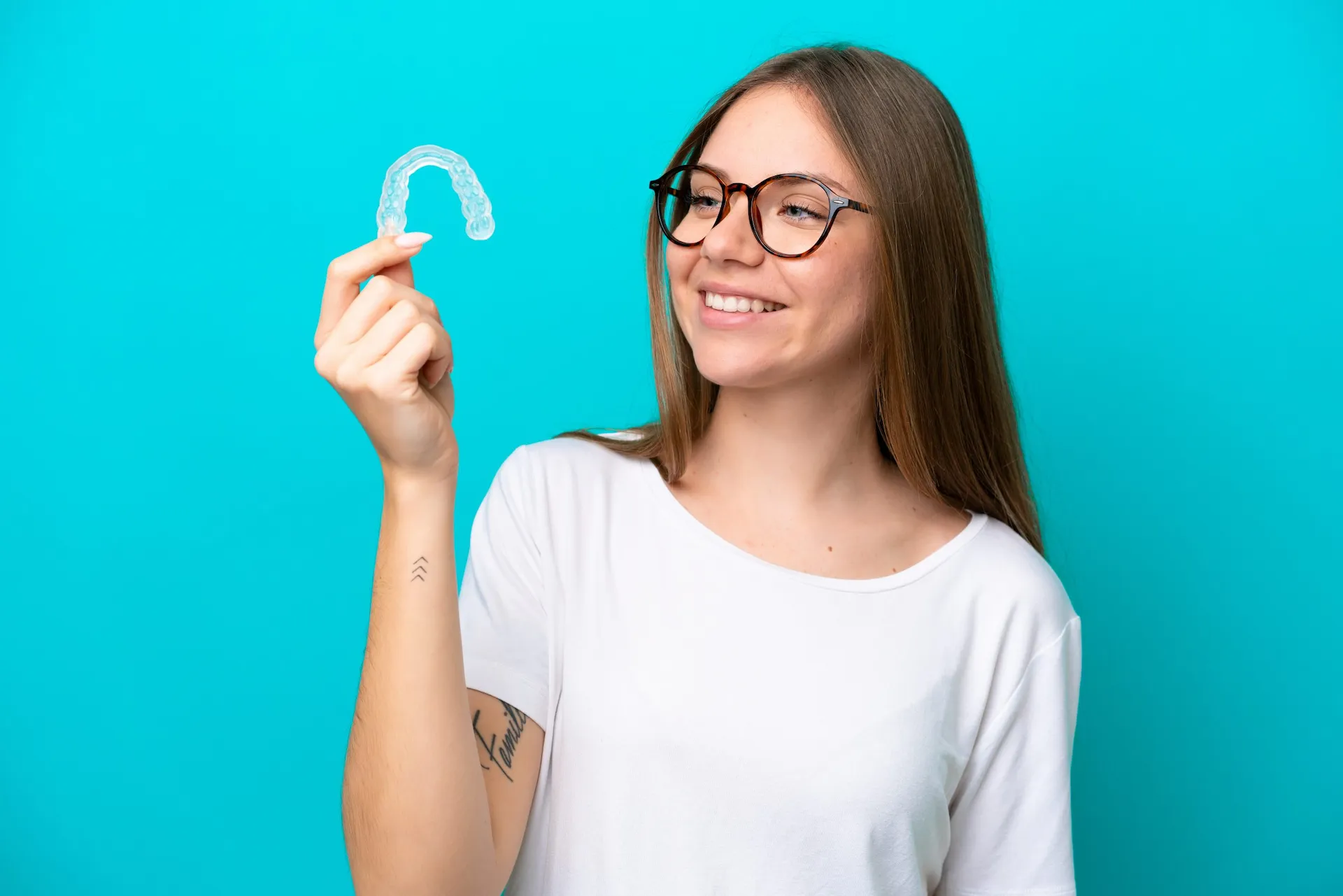 Young woman holding invisible braces isolated on blue background with happy expression Vitae proin sagittis nisl rhoncus mattis rhoncus urna neque